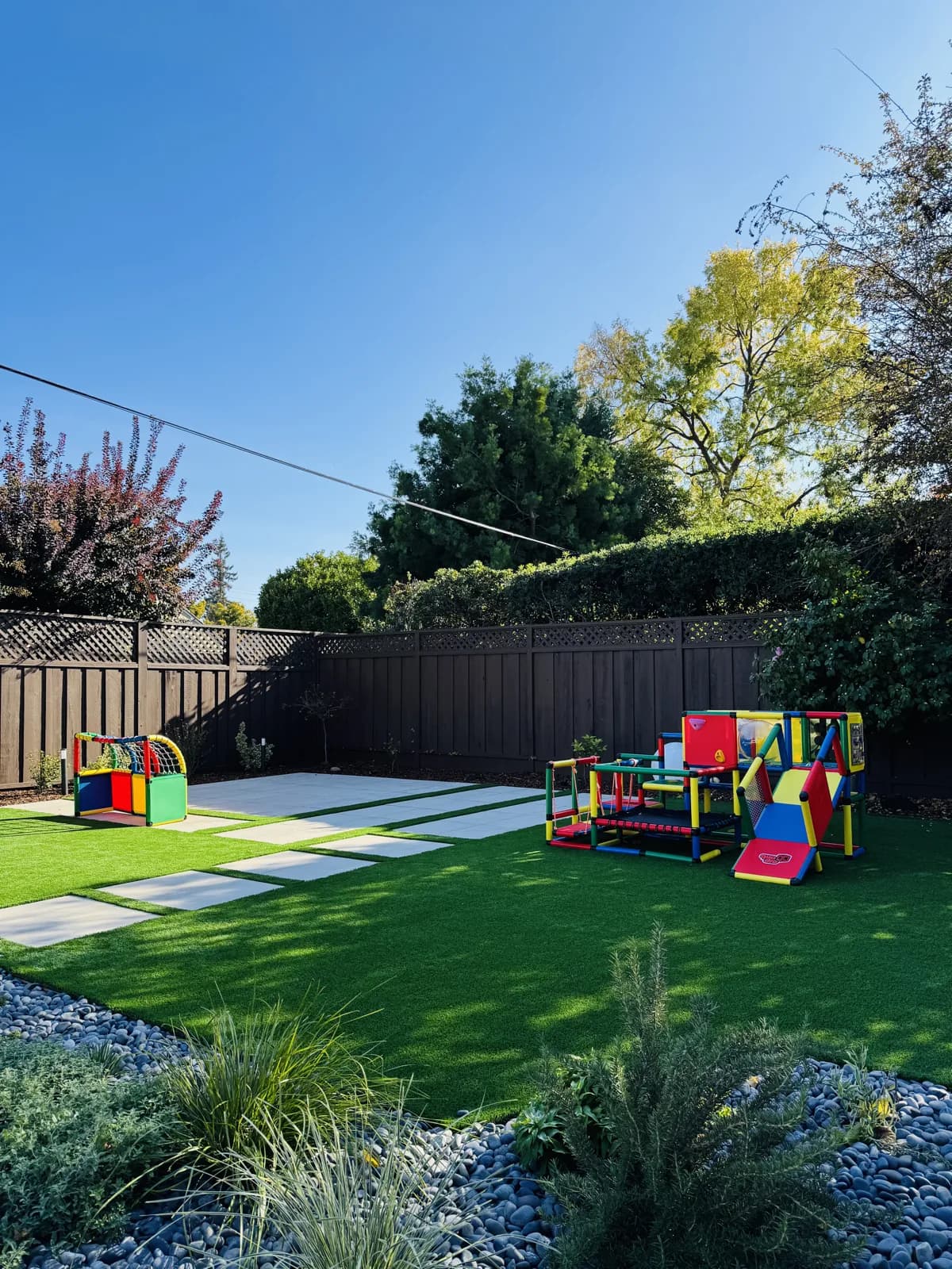Artificial turf play lawn with concrete stepping pads and children's play equipment